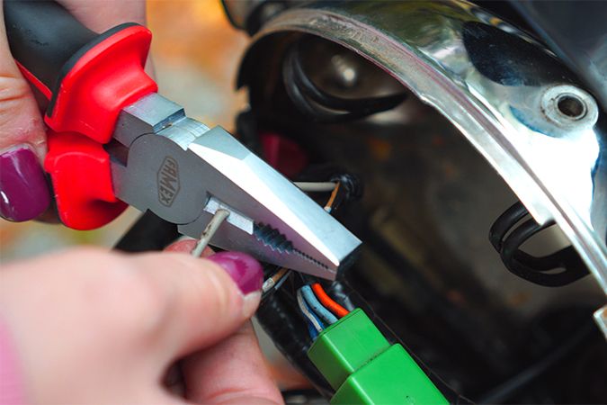 Graues Kabel mit einer Zange durchtrennen